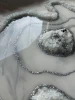 Zbliżenie na srebrne kruszywo i ciemny minerał w tacy z żywicy epoksydowej